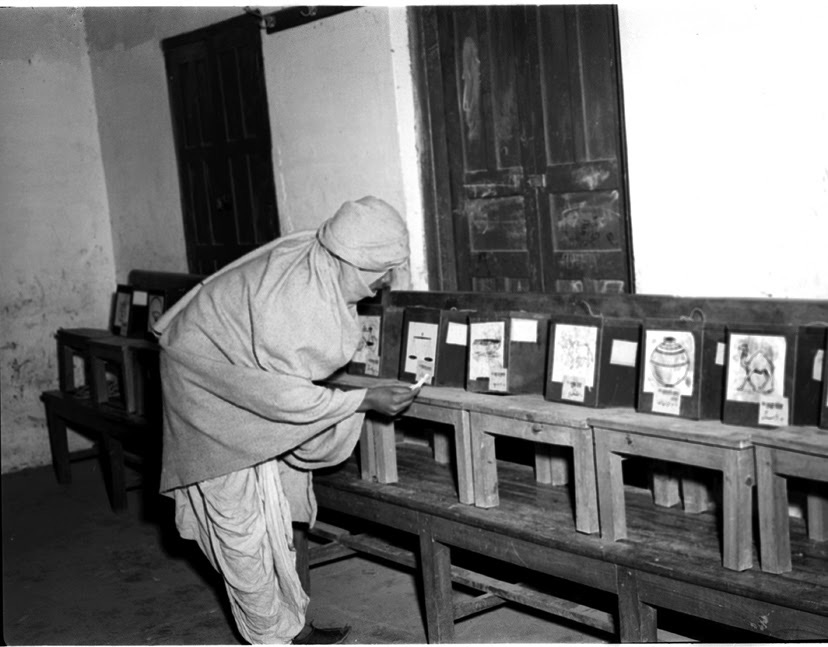A man at a polling station in Delhi in January 1952 studying the election symbols to find his candidate.